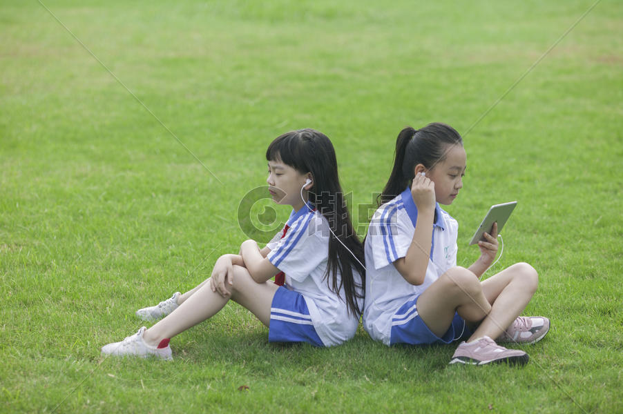 女同学在学校里草坪上用ipad 学习图片素材免费下载