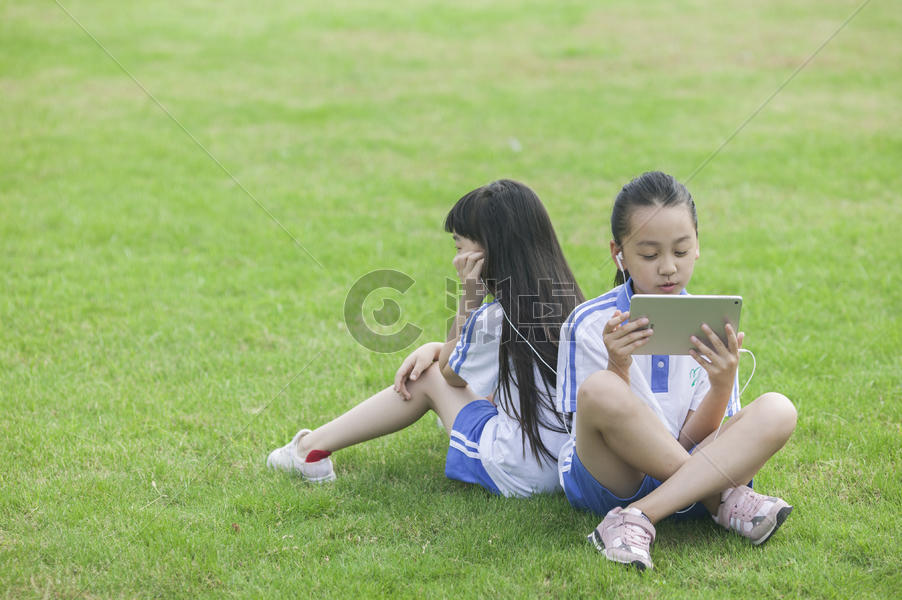 女同学在学校里草坪上用ipad 学习图片素材免费下载
