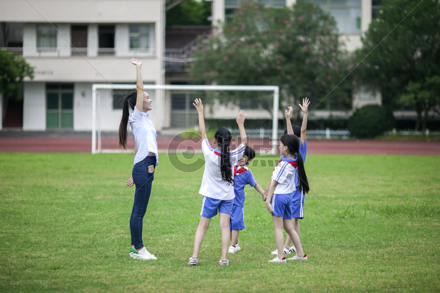 校园里女老师和同学们在草坪上一起玩耍图片素材免费下载