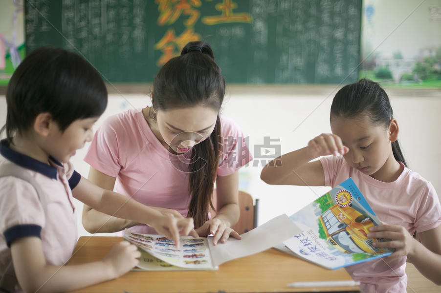 男女同学和女老师在教室里一起看书图片素材免费下载