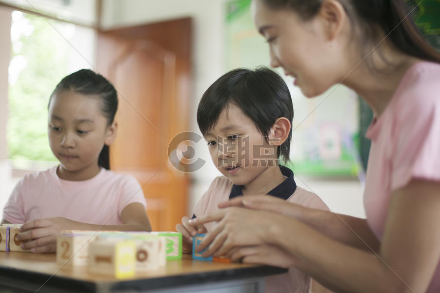 男女同学和女老师在教室里玩积木图片素材免费下载
