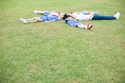躺在草坪上的小学生和老师图片素材免费下载