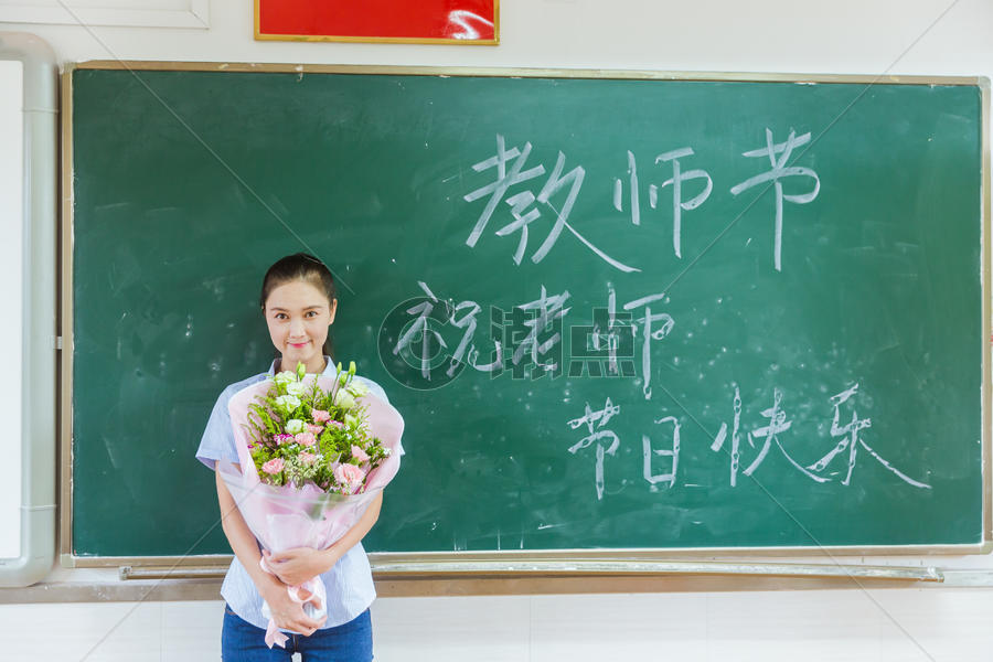 教师节老师拿着花在黑板前图片素材免费下载