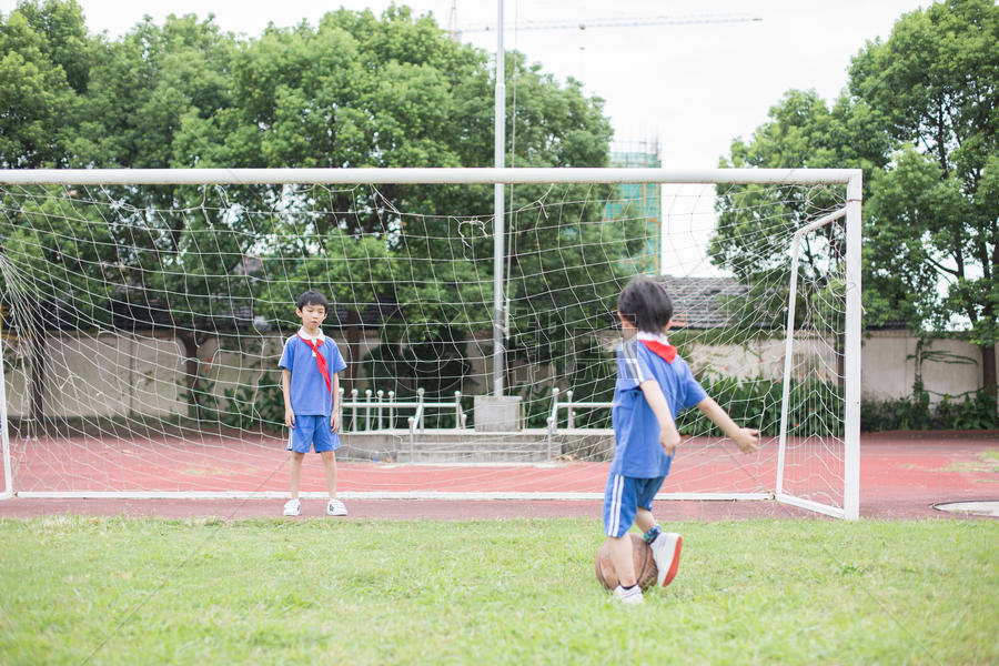 在球场上踢球玩耍的小学生图片素材免费下载