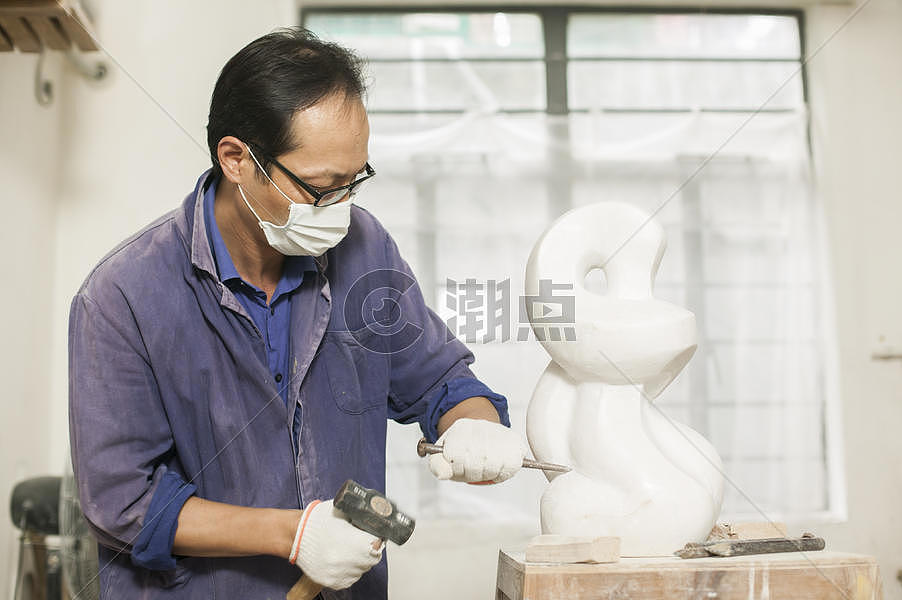 专注的石匠雕刻师傅在雕刻作品图片素材免费下载
