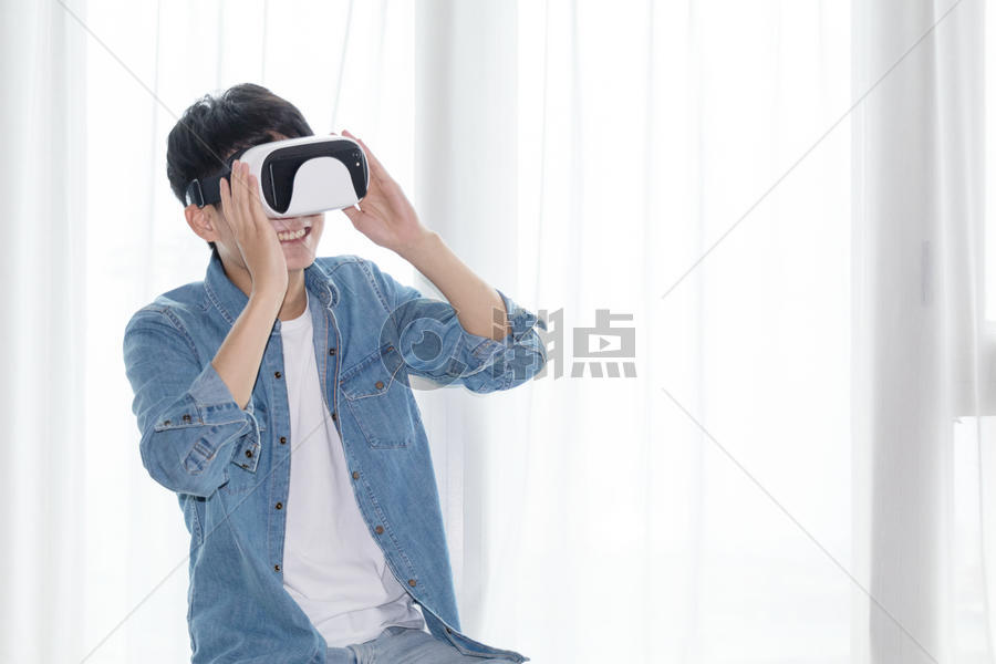 年轻男子在客厅体验虚拟现实VR眼镜图片素材免费下载
