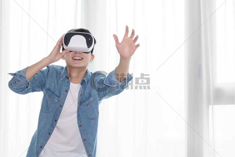 年轻男子在客厅体验虚拟现实VR眼镜图片素材免费下载