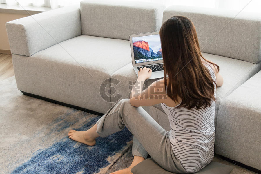 年轻女性在客厅使用家庭办公图片素材免费下载