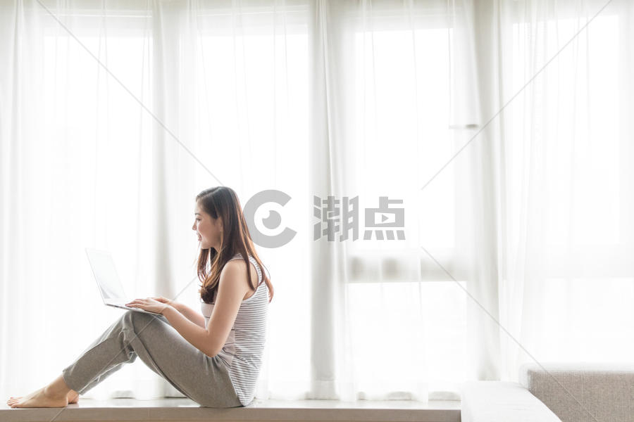 坐在窗台使用电脑休闲放松的女性图片素材免费下载