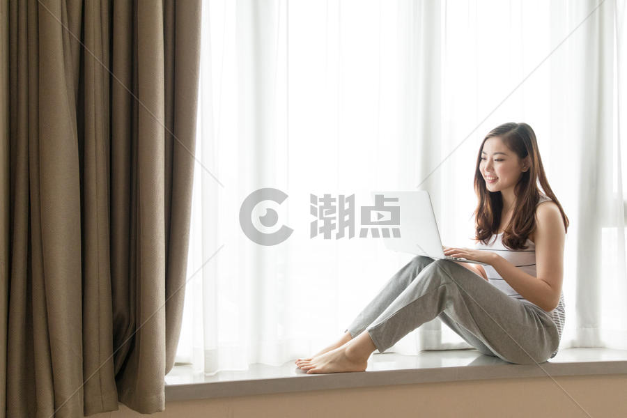 坐在窗台使用电脑休闲放松的女性图片素材免费下载