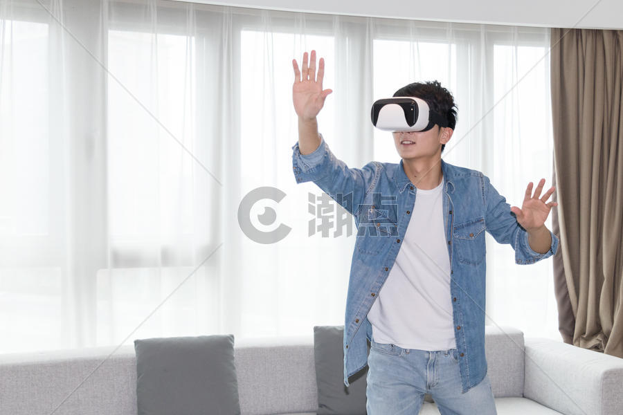 在客厅头戴vr眼镜体验虚拟现实的男士男人图片素材免费下载