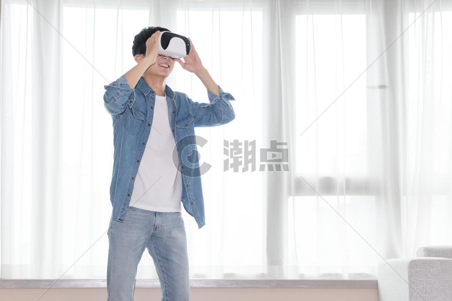 在客厅头戴vr眼镜体验虚拟现实的男士男人图片素材免费下载