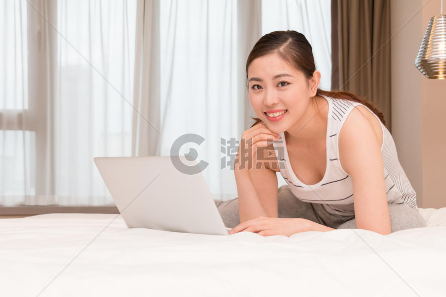 美女趴在床上玩电脑图片素材免费下载