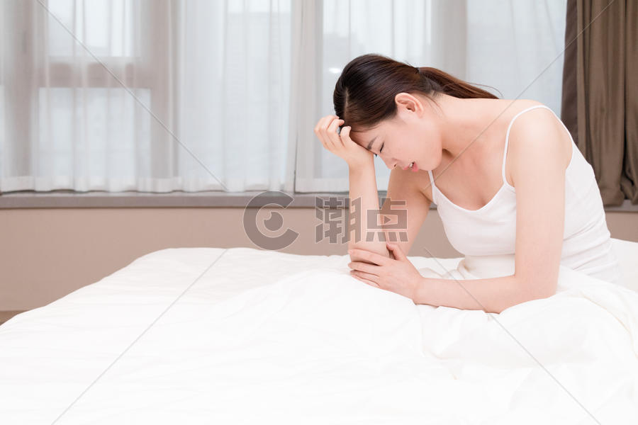 年轻女性失眠头痛坐在床上图片素材免费下载