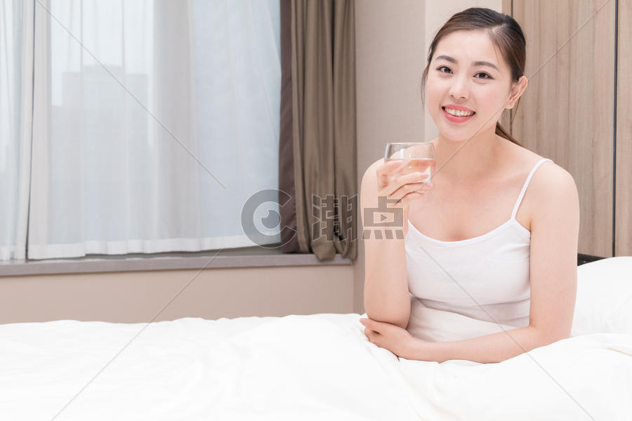 早起睡前坐在床上喝水的美女图片素材免费下载