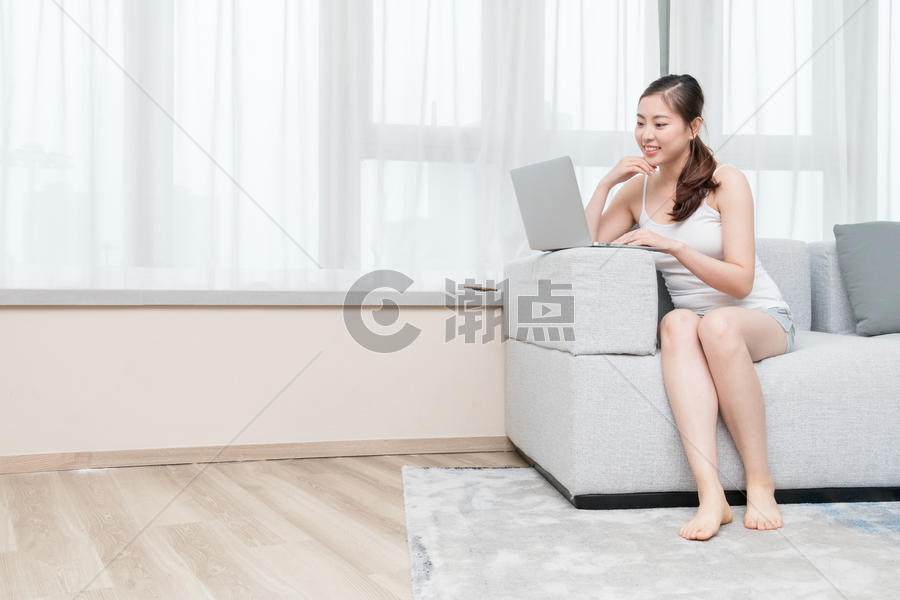 坐在客厅休闲放松玩电脑购物的女生图片素材免费下载