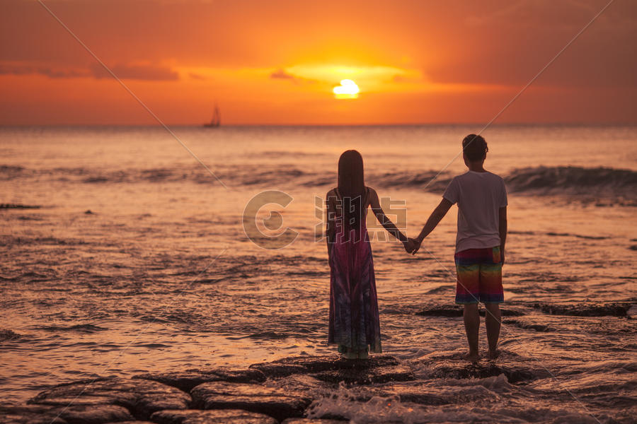 旅行中浪漫情侣在海中看夕阳图片素材免费下载