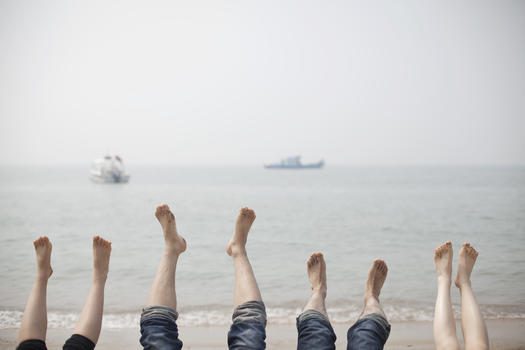 旅行中一家人在海边抬脚放松图片素材免费下载
