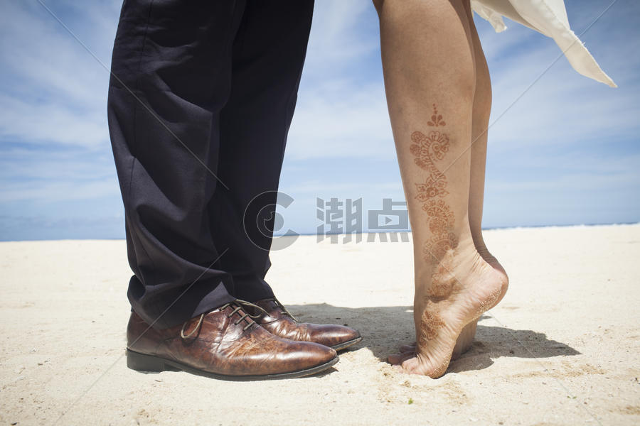旅行蜜月中情侣在沙滩踮起脚尖亲吻图片素材免费下载