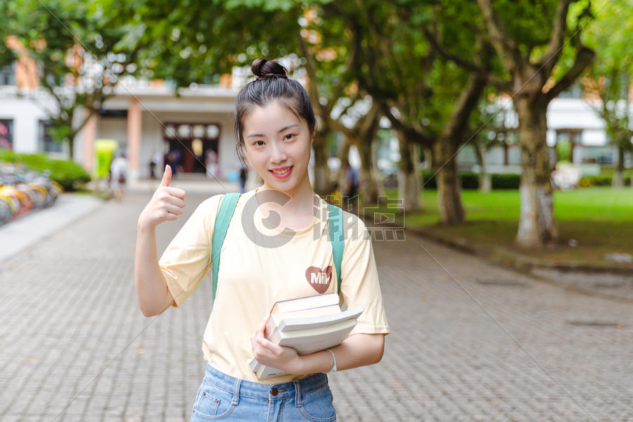 大学校园内女生抱着书本图片素材免费下载