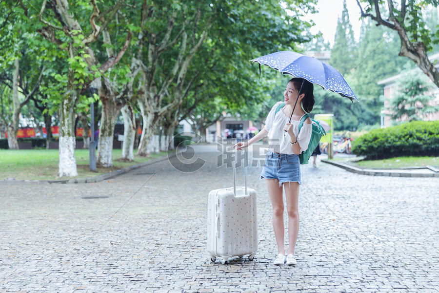 下雨天女生拉旅行箱张望图片素材免费下载