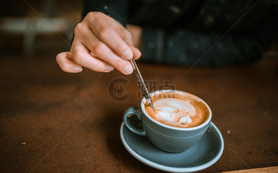 手拿勺子搅动咖啡图片素材免费下载