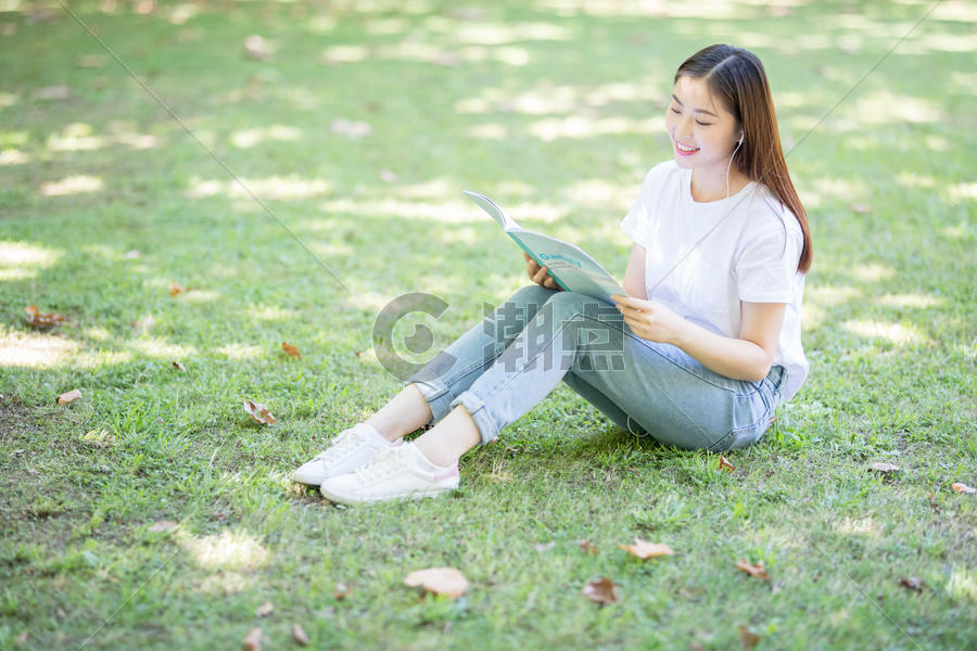 坐在校园草坪上看书的女学生图片素材免费下载