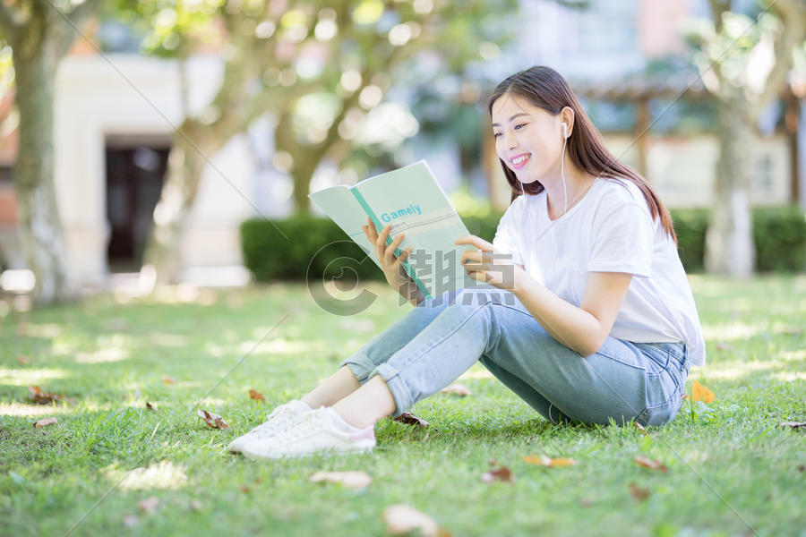 坐在校园草坪上看书的女学生图片素材免费下载