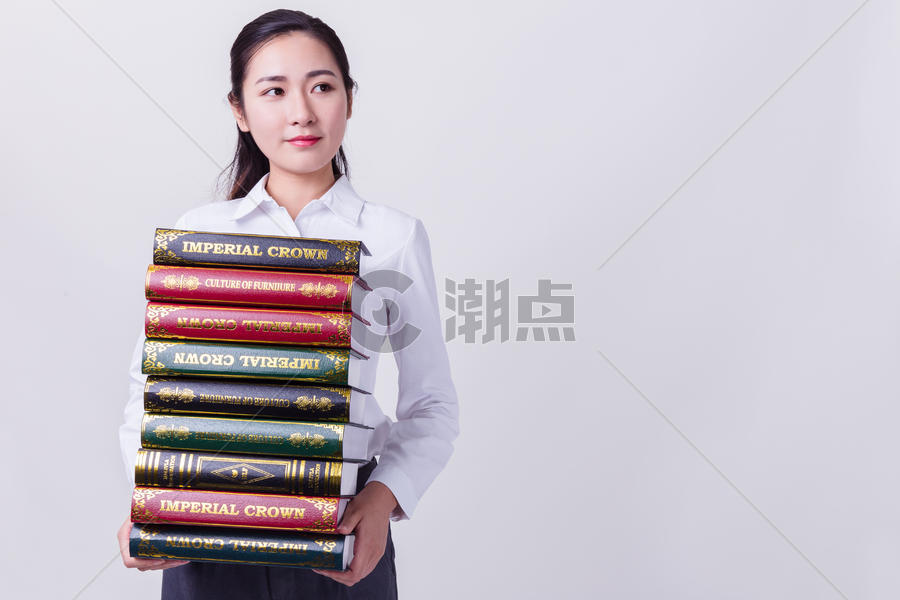 干练的商务女性抱着书籍思考图片素材免费下载