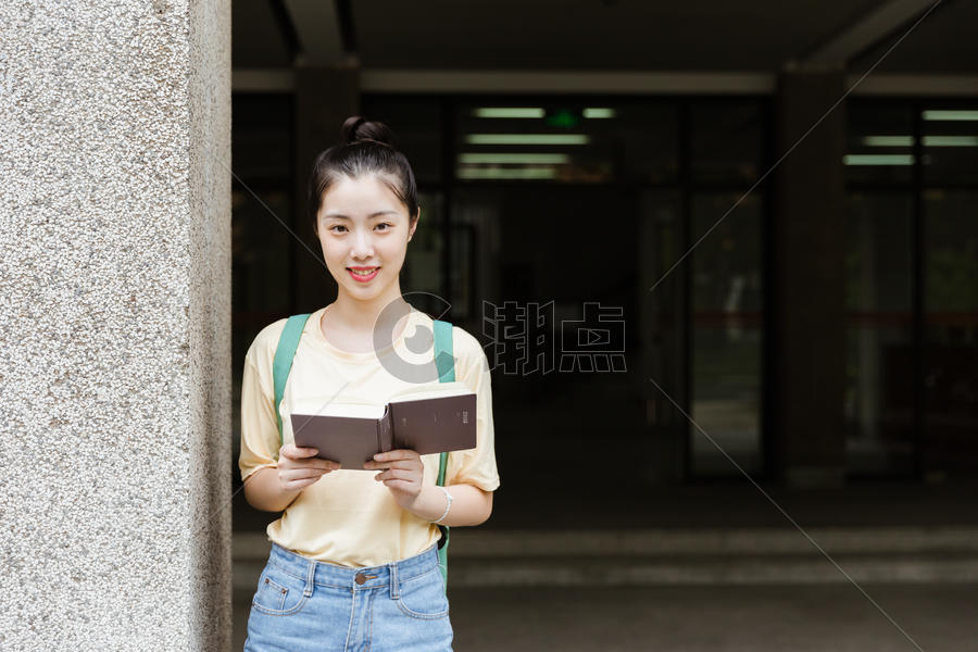 大学教学楼前女生在看书图片素材免费下载