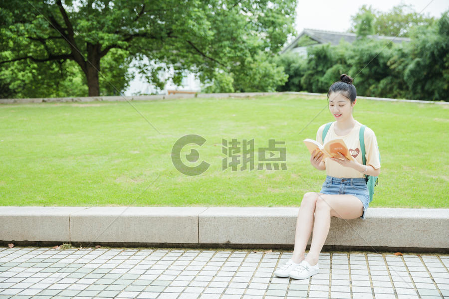 校园草地前女生在看书图片素材免费下载