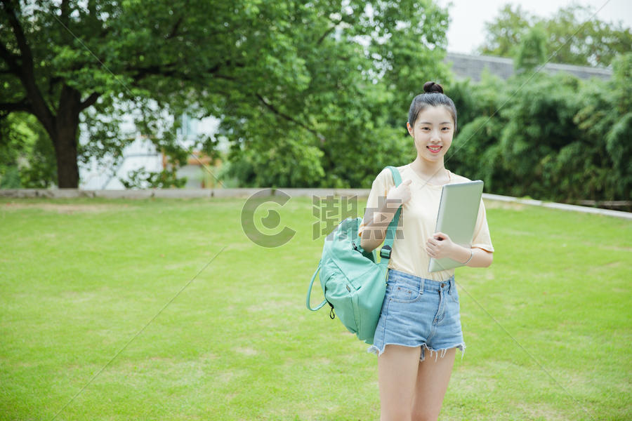 校园草地前女生抱着电脑图片素材免费下载