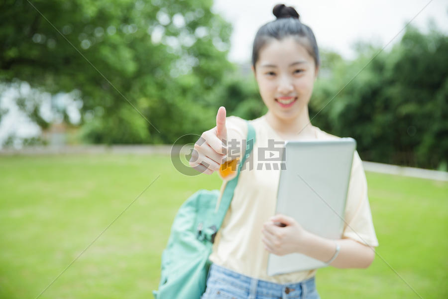 校园草地前女生举大拇指图片素材免费下载