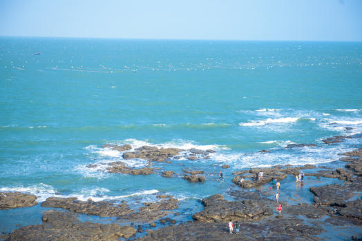 蓝色海岸线海滩边的礁石图片素材免费下载