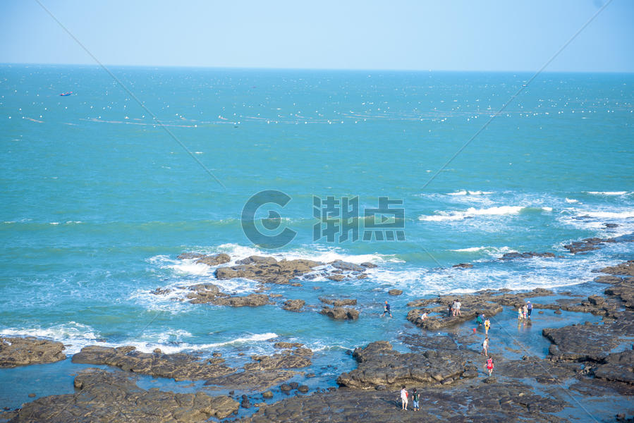 蓝色海岸线海滩边的礁石图片素材免费下载