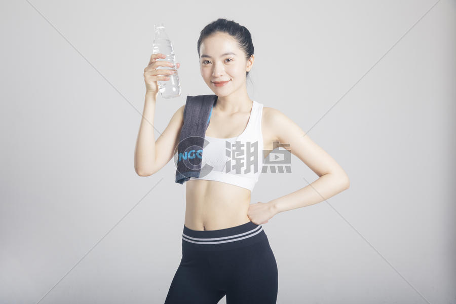 擦汗喝水的运动女性棚拍图片素材免费下载