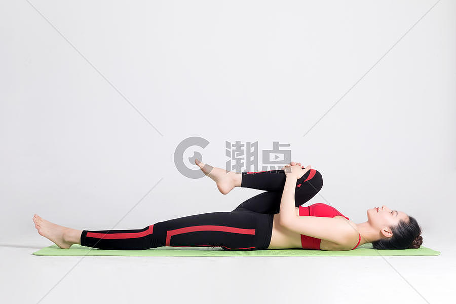 年轻女性在瑜伽垫上做瑜伽动作图片素材免费下载