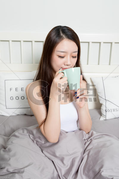 甜美女生坐在床上喝水图片素材免费下载