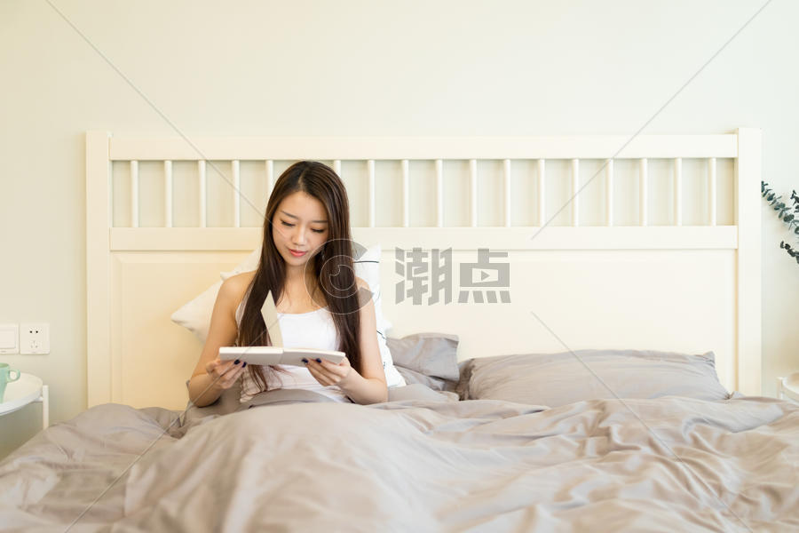 坐在床上看书的女生图片素材免费下载