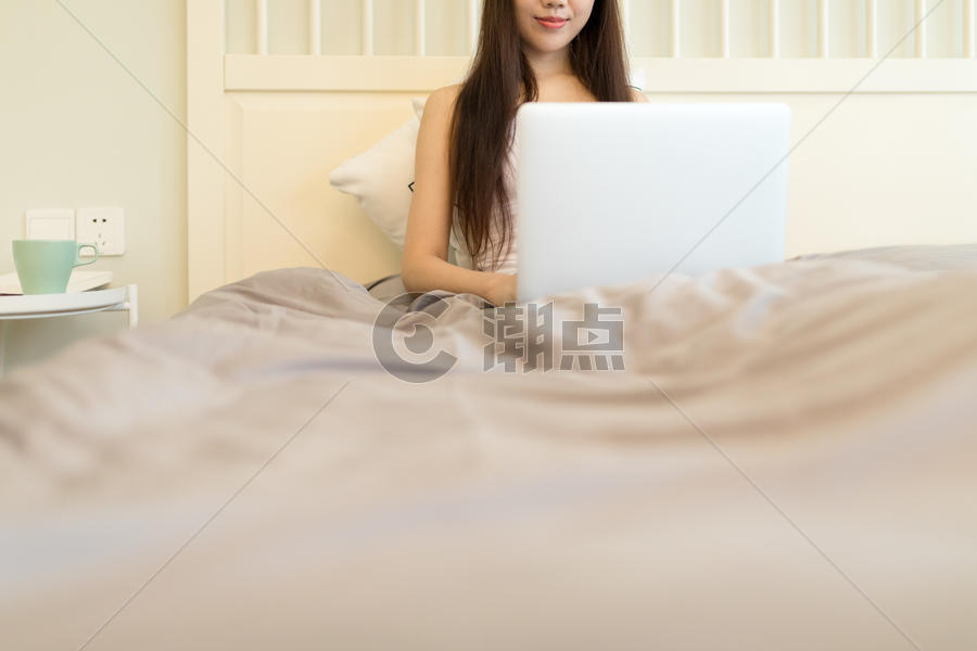 躺在床上玩电脑的年轻女性图片素材免费下载