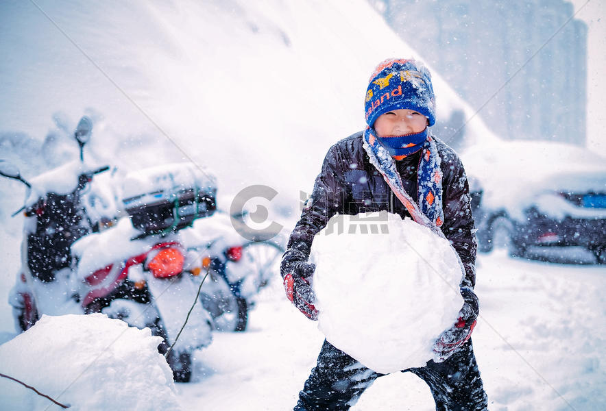 雪中堆雪球玩雪的男孩图片素材免费下载