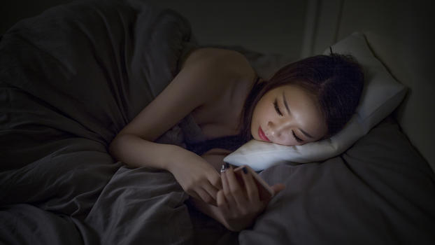 深夜睡前躺着玩手机的女生图片素材免费下载