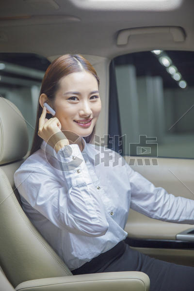 在车内戴蓝牙耳机通话的商务女性图片素材免费下载
