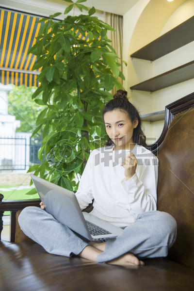年轻女性在沙发上看电脑图片素材免费下载