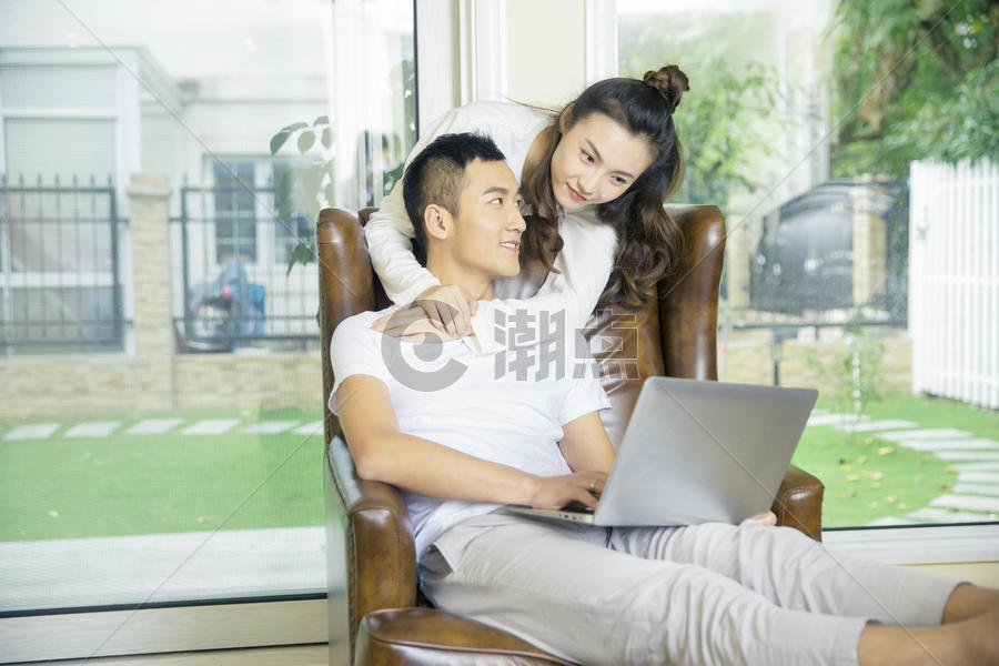 年轻夫妇在客厅玩电脑图片素材免费下载