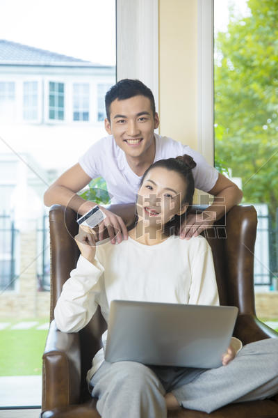 年轻夫妇在客厅用电脑网购图片素材免费下载