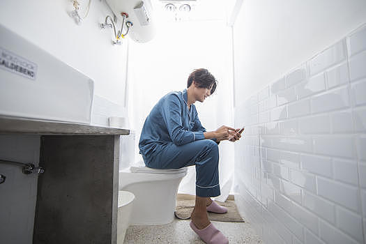 男生在厕所里看手机图片素材免费下载
