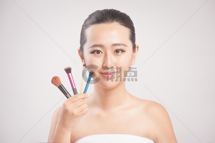 手拿化妆笔的人像妆容图片素材免费下载