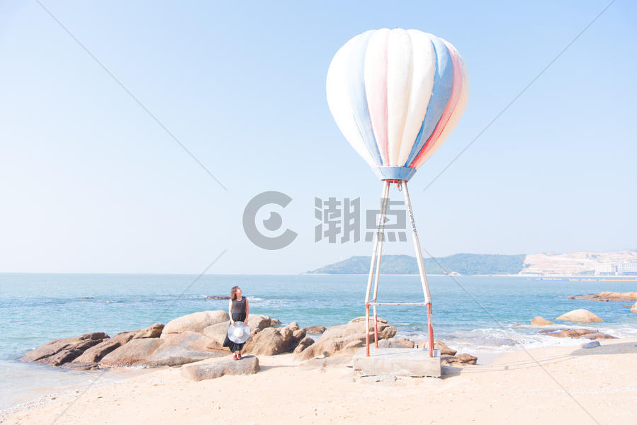 海边热气球旁聆听大海声音的女模特图片素材免费下载