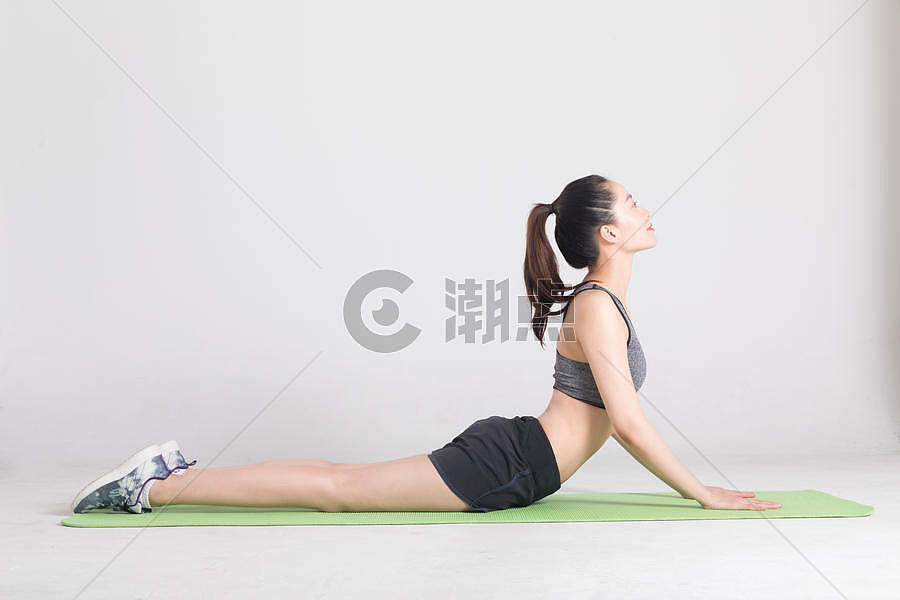 瑜伽垫上做运动动作的年轻女性图片素材免费下载